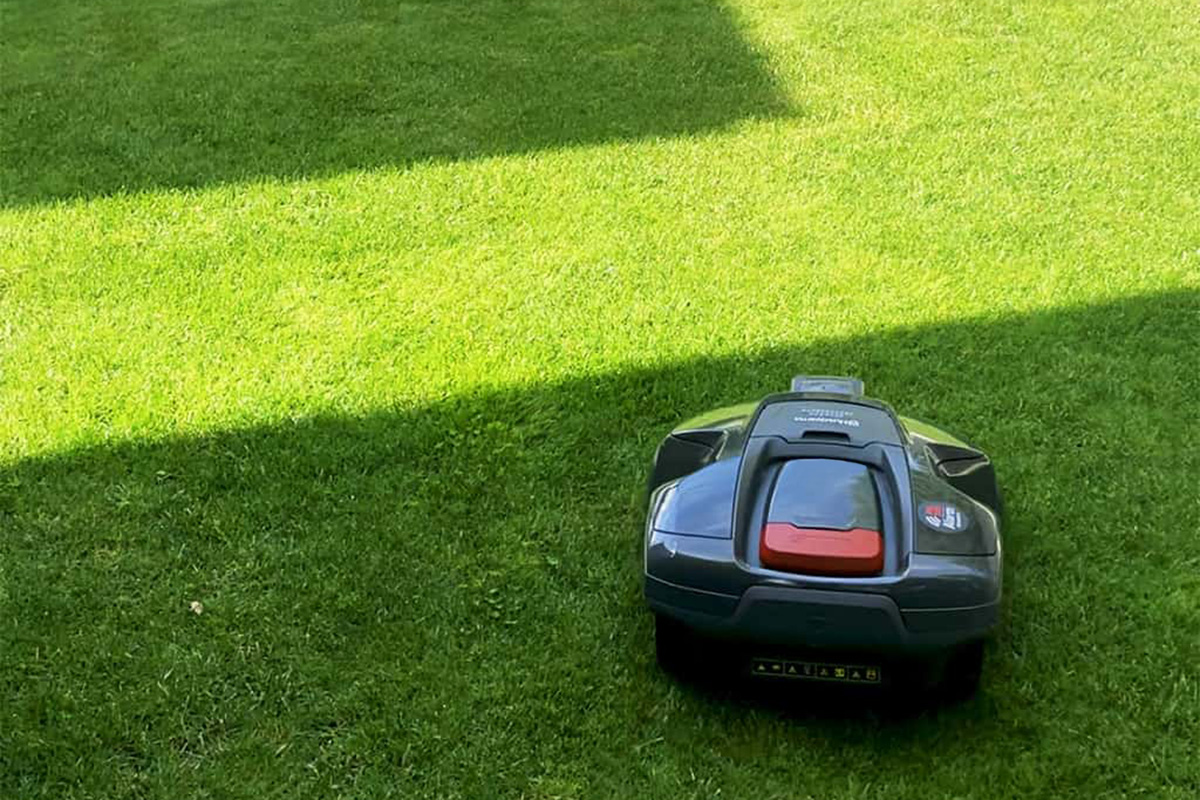 Robotgräsklippare som klipper gräsmattan efter luftad gräsmatta