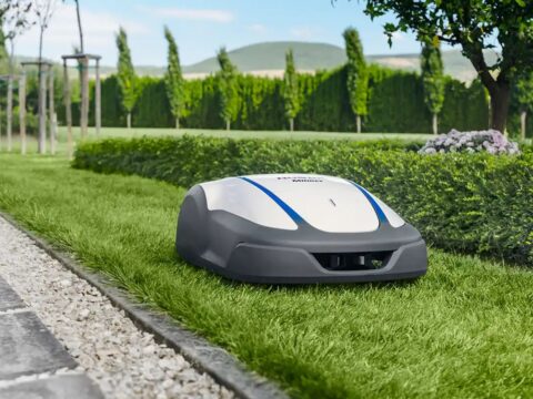 A robotic lawn mower is cutting grass in a garden.